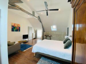 1 dormitorio con cama, sofá y TV en La Pillebourdiere, en Oisly