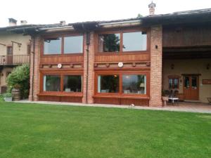a house with glass windows and a green lawn at Locanda Dei Gelsi in Villar San Costanzo