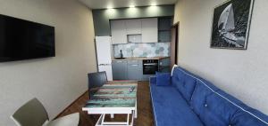 a living room with a blue couch and a kitchen at Апартаменты с видом на море in Odesa