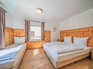 um quarto com 2 camas e uma janela em Chalet Kirchberg em Kirchberg in Tirol