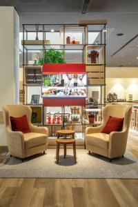 two chairs and a coffee table in a room at IntercityHotel Budapest in Budapest