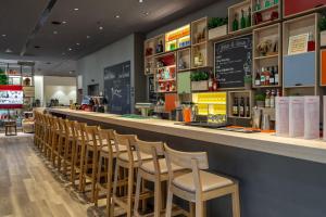 un bar con una fila di sedie in un ristorante di IntercityHotel Budapest a Budapest