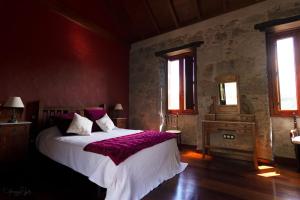 テロルにあるCasa Rural Las Caldererasのベッドルーム1室(紫のシーツが敷かれた大型ベッド1台付)