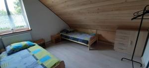 a bedroom with two beds in a attic at Apartament pod lasem in Bandrów Narodowy