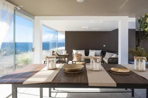 uma mesa de jantar numa sala de estar com vista para o oceano em Villa Luxury Punta de Teno - Canary Good Vibes em Buenavista del Norte