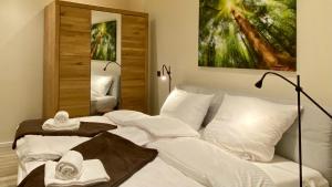 a bedroom with a white bed with towels on it at wohlBfinden appartementhaus in Braunlage