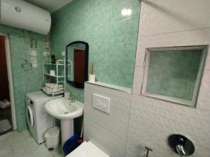 een badkamer met een wastafel, een toilet en een spiegel bij Mammy's Home in Tirana