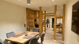 a dining room and kitchen with a wooden table and chairs at wohlBfinden appartementhaus in Braunlage