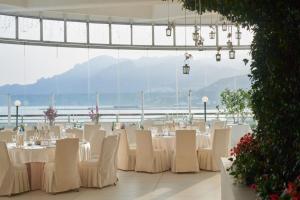 サレルノにあるグランド ホテル サレルノの白いテーブルと椅子が備わる宴会場