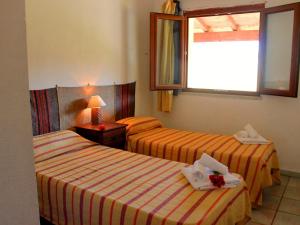 a hotel room with two beds and a window at d Pietraia 13B Trilo in Badesi