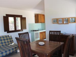 una cucina e una sala da pranzo con tavolo e sedie in legno di c Scalitti 10C Bilo a Badesi
