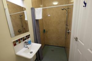 ein Bad mit einem Waschbecken und einer Dusche in der Unterkunft Wayfarers Independent Hostel in Penrith