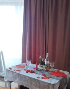 een tafel met rode rozen en een fles wijn bij Apartment on Dacia in Chişinău