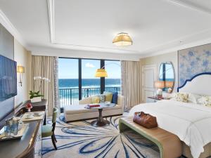 a bedroom with a large bed and a view of the ocean at The Breakers Palm Beach in Palm Beach