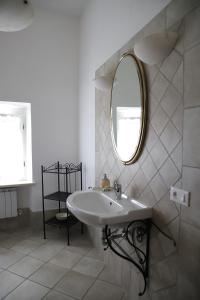 a white bathroom with a sink and a mirror at Agriturismo Escaia in Volterra