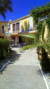 a building with tables and chairs in front of it at Hotel Hélios in Cap d'Agde