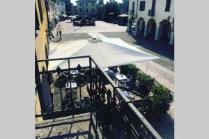 un ombrellone bianco seduto sopra un balcone di Green Appartamenti i Portici nel centro storico a Melzo Altre 5 foto