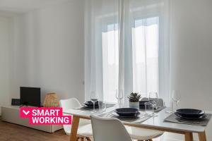 een witte eetkamer met een tafel en stoelen bij Deluxe Apartments by Wonderful Italy in Genua