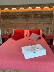 uma cama rosa com duas toalhas em cima em Ca di Nadia em Aosta
