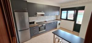 a kitchen with blue cabinets and a table in it at CASA CAXOTA: Planta baja con terraza y vistas al mar in Fisterra