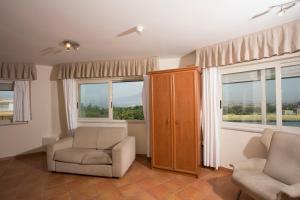 ein Wohnzimmer mit 2 Stühlen und 2 Fenstern in der Unterkunft Hotel Villa Serena in Castellammare di Stabia