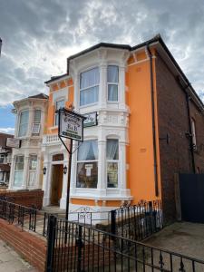 een oranje gebouw met een bord ervoor bij Waverley Park Lodge in Portsmouth