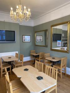 a dining room with tables and chairs and a chandelier at Waverley Park Lodge in Portsmouth