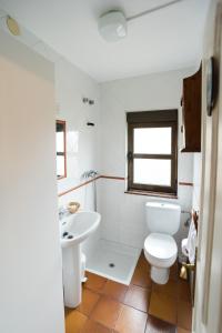 Łazienka z białą toaletą i umywalką w obiekcie Casa Rosaura w mieście Naveda
