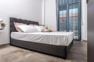 a bedroom with a large bed with white and pink pillows at Halkidiki beach apartments 1 Nea Kallikratia Vergia beach in Nea Kalikratia