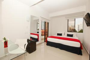 a hotel room with two beds and a television at Zalmedina Hotel in Cartagena de Indias
