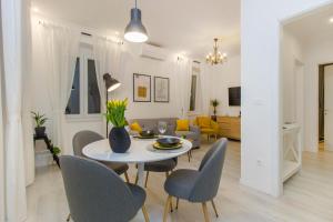 a dining room and living room with a table and chairs at Apartment Ena ,city center in Šibenik