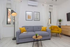 a living room with a blue couch and a yellow chair at Apartment Ena ,city center in Šibenik