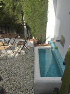 una piscina con mesa y sillas junto a un edificio en San Miguel B&B Granada, en Granada