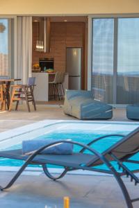 a large swimming pool in a living room with a kitchen at Blue Velvet Coast Luxury Villas in Kokkíni Khánion
