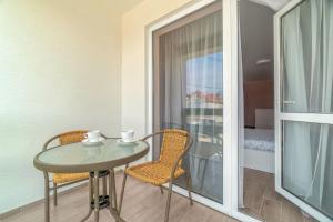 a room with a table and two chairs and a balcony at Flamingo Family Club in Karolino-Buhaz