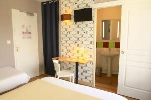 Cama ou camas em um quarto em Logis Hôtels- Hôtel Marguerite d'Anjou Angers château