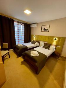 una habitación de hotel con 2 camas y una silla en Penzion Nevada, en Dunajská Streda