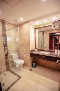 y baño con aseo, lavabo y ducha. en Lamar Azur Hotel, en Dumyāţ al Jadīdah