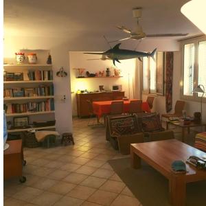 uma sala de estar com um sofá e uma ventoinha de tecto em Attico sul Porto Vecchio - Lampedusa em Lampedusa