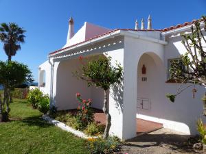 a white house with a garden in front of it at Ocean facing at Senhora da Rocha in Porches