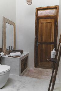 bagno con servizi igienici e porta in legno di Adara Homestay a Banyuwangi