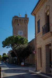 uma torre alta com um relógio no lado de um edifício em Casa Ludovica em Porto Recanati