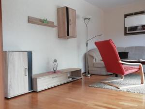 a living room with a red chair and a couch at Meyers Ferienwohnung in Elmlohe