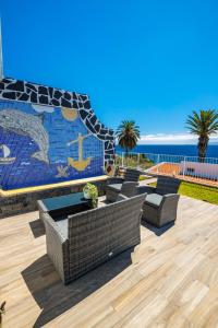 un patio amueblado y un mural del océano en Casa Maravilha III, en Caniço