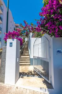 un cancello bianco con fiori viola su un edificio di Casa Maravilha III a Caniço
