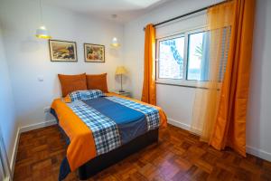 1 dormitorio con cama y ventana en Casa Maravilha III, en Caniço