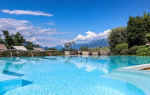 a large blue swimming pool with mountains in the background at Villa Elena appartamento in villa in Montinelle