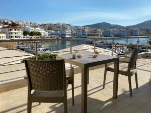 een tafel en stoelen op een balkon met uitzicht bij Magic View Apartment-Karpathos Port Pigadia in Karpathos
