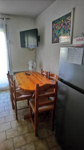 a kitchen with a wooden table and a refrigerator at Appartement 4 personnes 5mn plage Piscine wifi parking in La Seyne-sur-Mer
