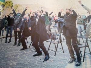 a group of people standing in chairs with their hands in the air at Casa di Alice in Gorizia